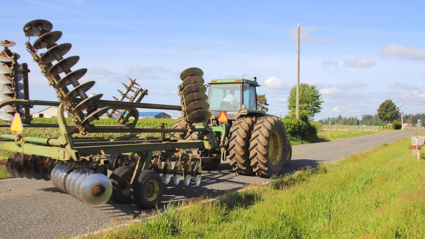 Piece of farm equipment driving on road Piece of farm equipment driving on road