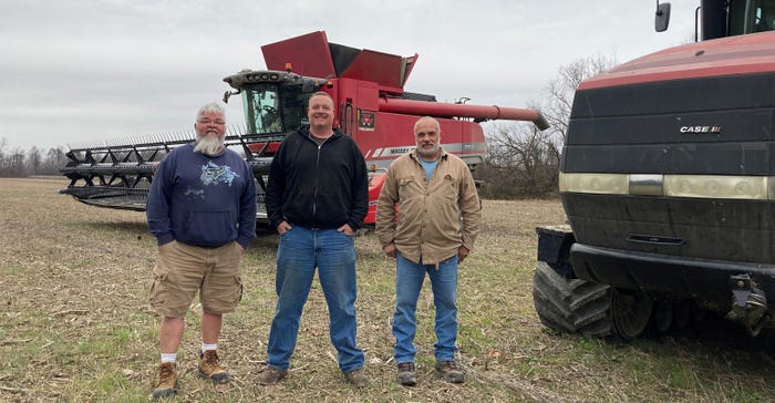 Randy Webb, Scott Nelson and Mark Kappel in newly harvested field with equipment behind them