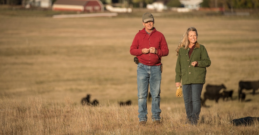 Dean and Candice Lockner standing in the hills of a pasture