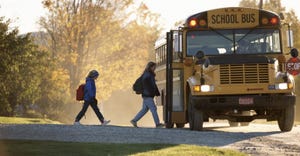 two children boarding stopped school bus