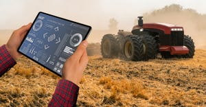 farmer with digital tablet controls an autonomous tractor