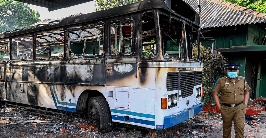Burned bus and police officer in Sri Lanka