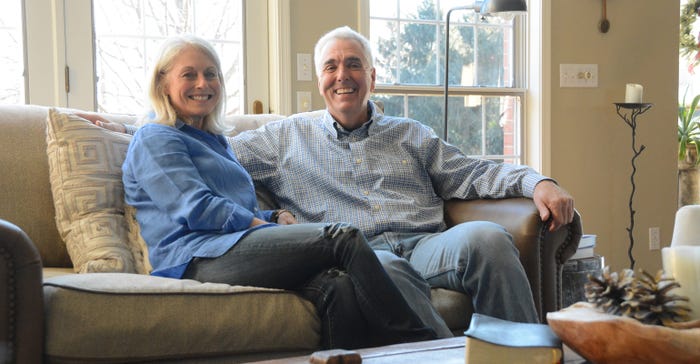 Doug and Stacy Schroeder sitting on a couch in their home