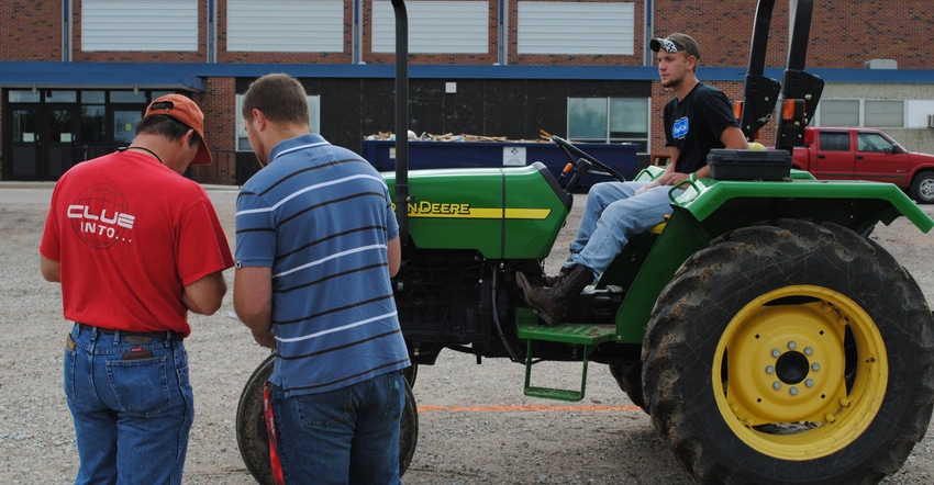  men taking a course on atv and tractor training- one man is on tractor while two others observe.