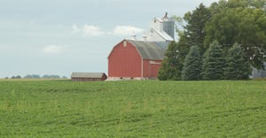 crops with red barn in background