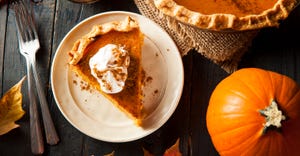 pumpkin pie, silverware and pumpkin on table