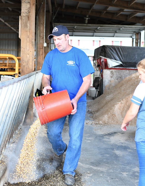 Jeremy Beebe with dumping grain seed from bucket