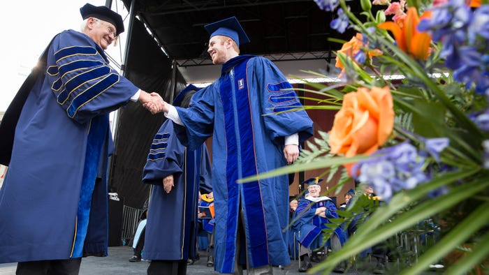 Bob Easter shakes young man's hand during a graduation ceremony