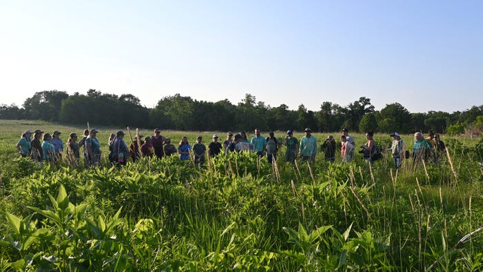 Adult students lined up in field
