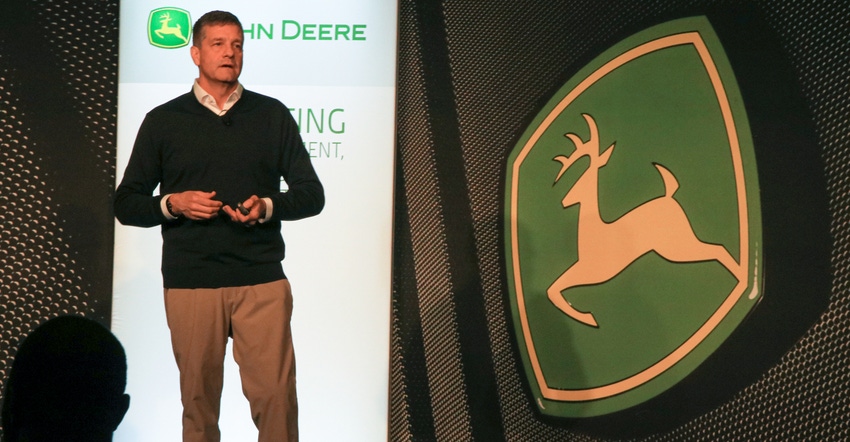 Lane Arthur stands next to John Deere logo