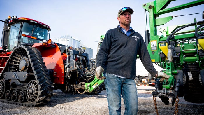R.H. Habbe stands next to farming equipment R.H. Habbe stands next to farming equipment