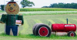 painted hay bales to look like farmer and a tractor in a field