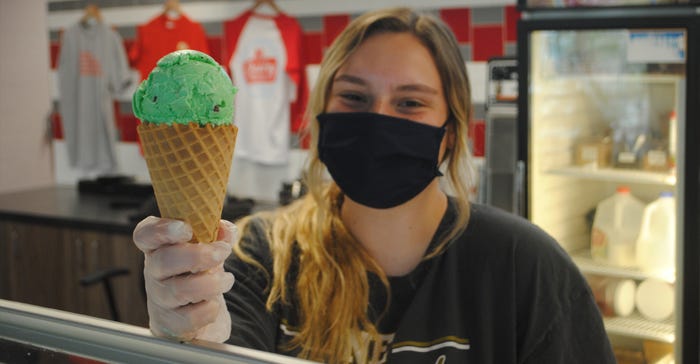 Dairy Store worker, Leyna Sand, Lincoln, serves up a single-scoop of 4-H Clover Mint ice cream in a waffle cone