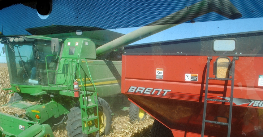 View of off-loading of corn through the back window of a combine