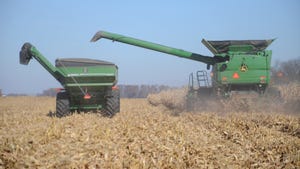 combine harvesting corn into grain cart