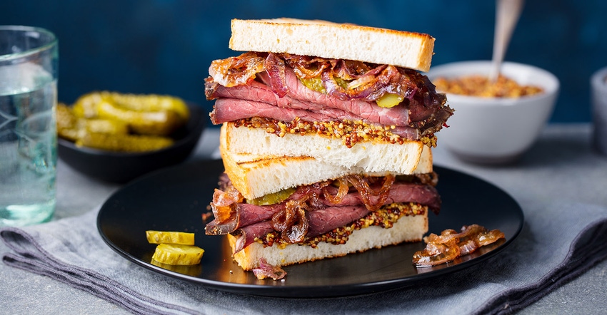 Roast beef sandwich on plate with pickle