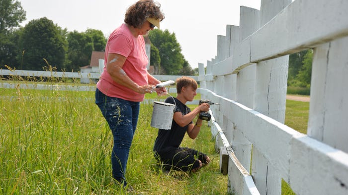 woman and teen repair and paint fence
