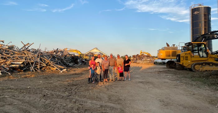 The Eachus family stands in the wreckage caused by a tornado