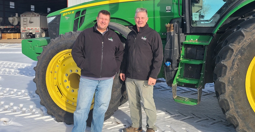Matt Furlong [left] and Bryant Knoerzer standing in front of tractor