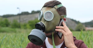 Man calling during isolation due to viral outbreak sitting in field of grass