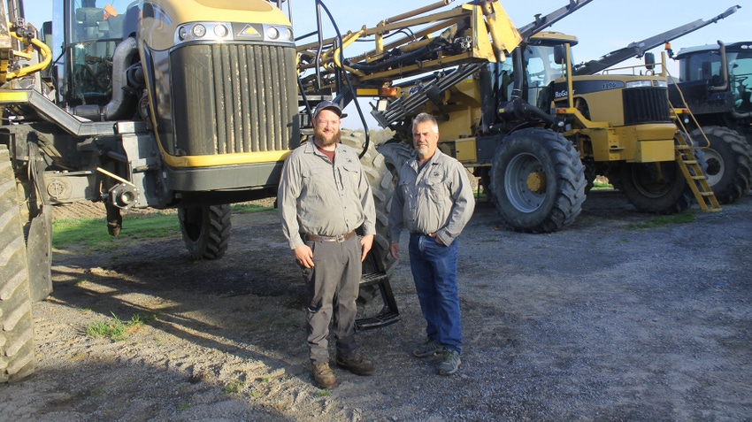 Dean Wheeler and A.J. Goblewski of D&D Spray Service standing in front of row of sprayers