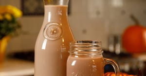Chocolate milk in a glass carafe and glass mug
