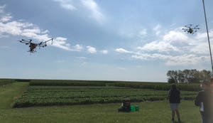two drones swarm in field