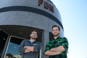 Two men standing outside building with FBN on it
