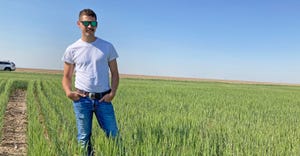 Kyler Millershaski, Lakin, Kan., stands in his field of Joe, a white winter wheat variety