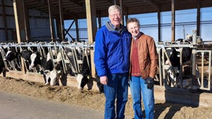 2023 Wisconsin Master Agriculturists Eric and Carol Hillan with dairy cows at feeder in the background