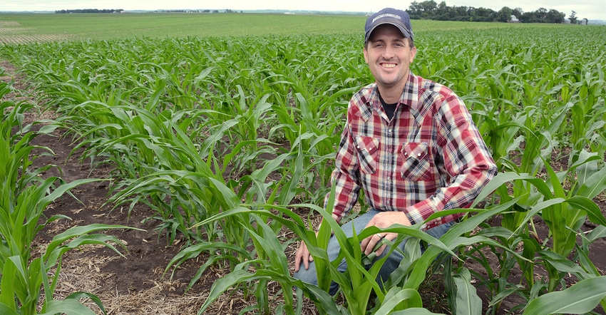 Jason Kontz kneels in no-till corn