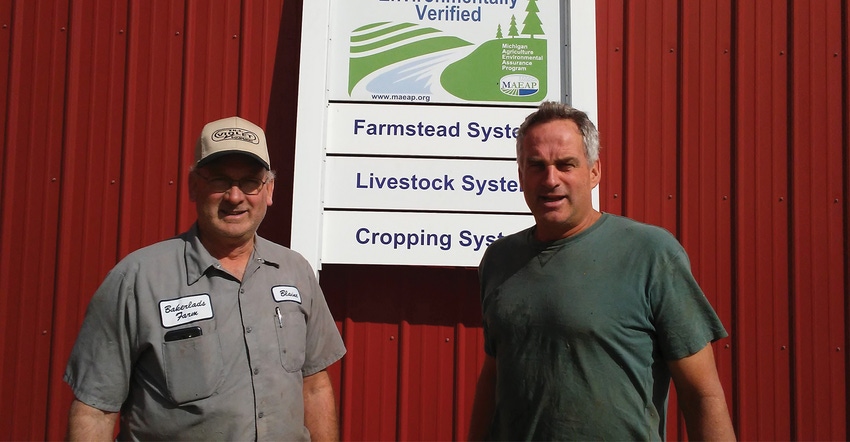 Blaine and Kim Baker of Bakerlads Farms stand infront of  a farmstead system livestock system and cropping system sign on a r