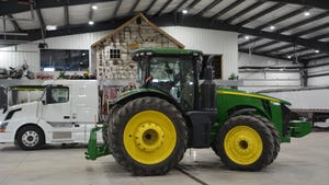 interior view of white farm shop with John Deere tractor parked inside