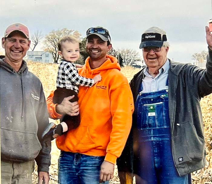 Three farmers, one holding small child
