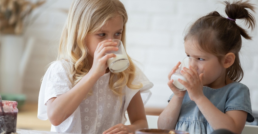 2 young girls drinking milk