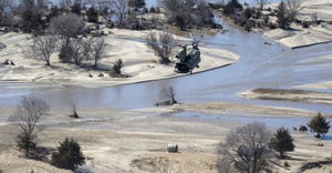 A CH-47 Chinook helicopter with the Nebraska National Guard drops a hay bale to cattle near Richland, Neb. on March 20