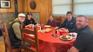 Hunter Johnson, Donnie Holupka, Paige Trumble, Dominic Gittlein and Coach Blaine French table eating dinner.