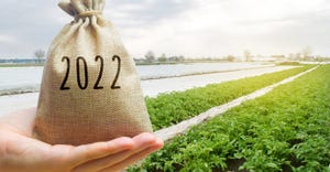 Money bag 2022 in the hands of a farmer and agricultural plantations