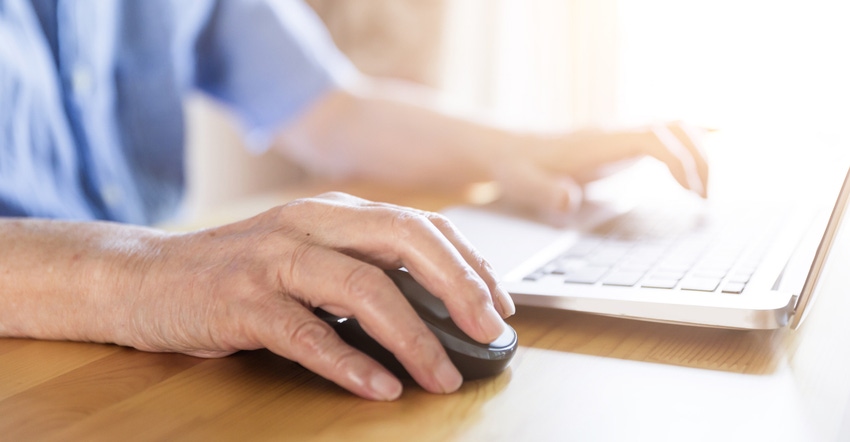 mature man using computer keyboard and mouse