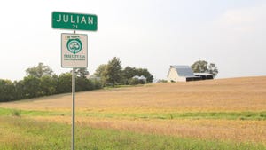 town road sign with farmland and barn in background
