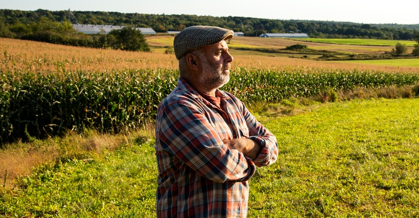 farmer looking out across farmland with look of concern farmer looking out across farmland with look of concern