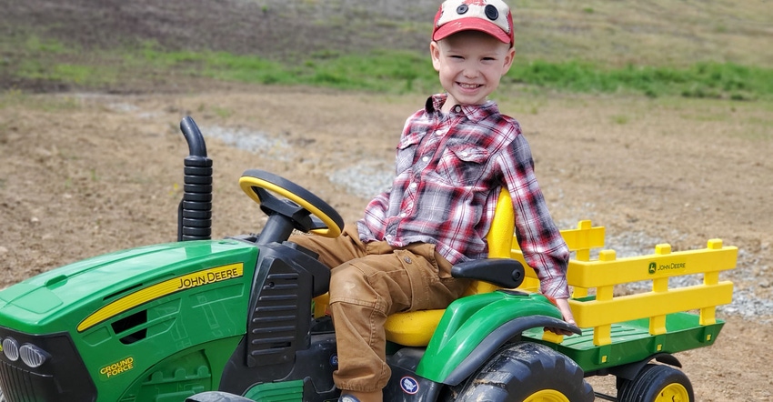 Cole Reskovac drives his preschool-size John Deere tractor complete with cart