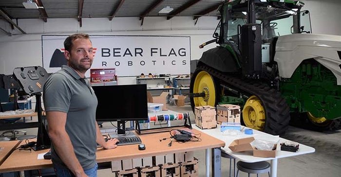 Daniel Carmichael in shop with Bear Flag Technology on the wall behind him.