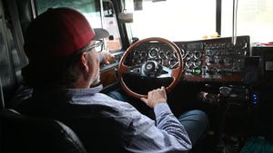 A farmer in the drivers seat of a semi truck