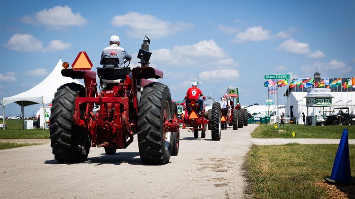 A parade of tractors at an exhibition