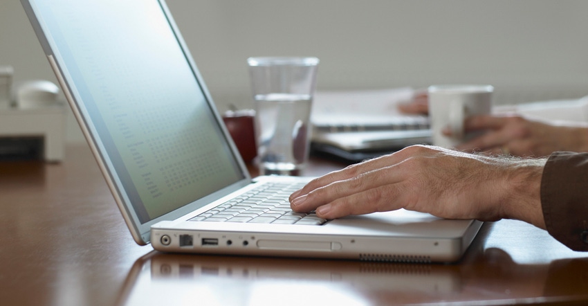 Closeup of male hands typing on a laptop