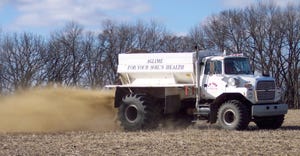 A truck applying applying ag lime on a field 