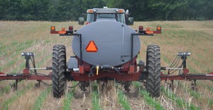 tractor applying fertilizer to planted crops