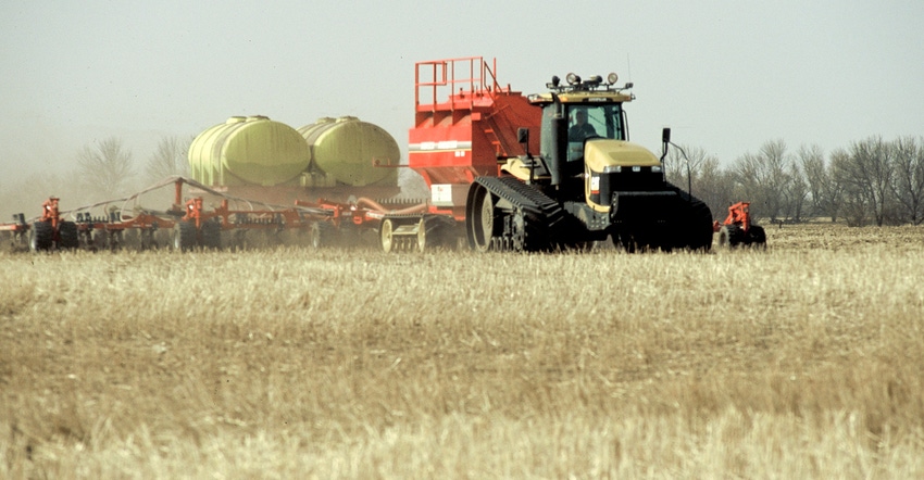 A large tractor planting seed on a field
