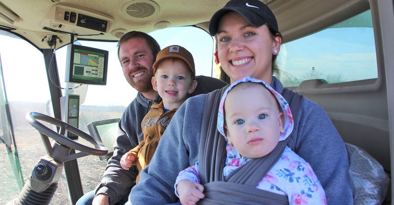 Young farmers Troy Meinke (far left) and his wife Stacy, Thomas and daughter Clara  inside combine cab